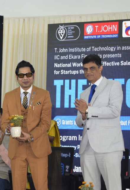 Two guests on stage after being felicitated with saplings
