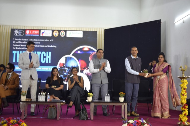A guest receives a sapling while the panel applauds