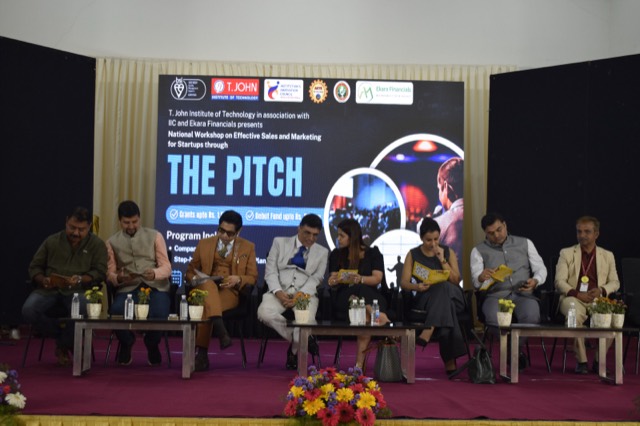 Panel members on stage reviewing the programme