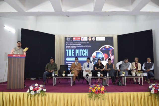 A speaker addresses the workshop with the panel on stage