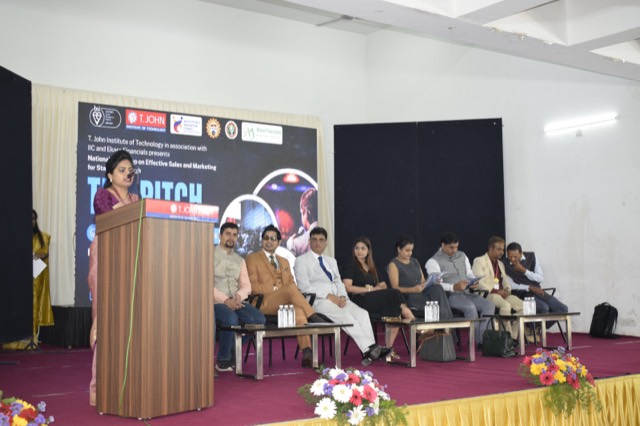 Welcome address delivered from the podium as the panel looks on