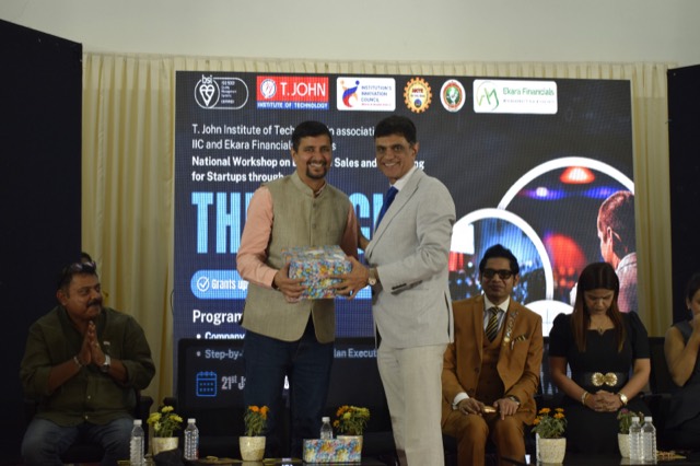 A guest is presented with a memento by a member of the panel