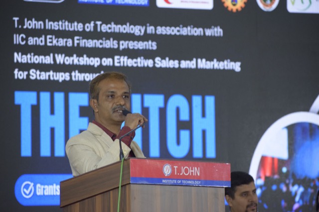 A speaker addresses participants in front of THE PITCH banner